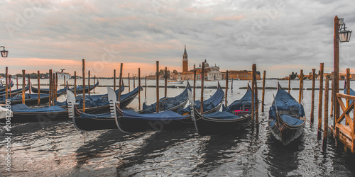 ondolas moored by Saint Mark square with San Giorgio di Maggiore church in Venice photo