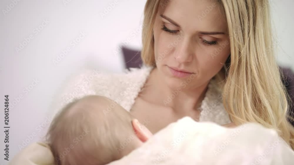 Young mother breast feeding new born child. Close up of woman breastfeeding baby. Toddler eating mother milk. Portrait of beautiful mother holding baby. Enjoy motherhood Young mother breast feeding new born child. Close up of woman breastfeeding baby. Toddler eating mother milk. Portrait of beautiful mother holding baby. Enjoy motherhood