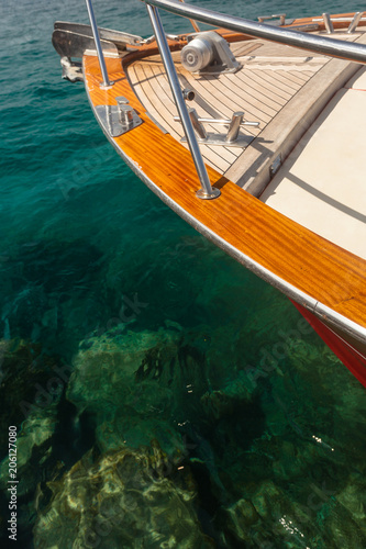 Hidden Danger - Bow Tip of a private Yacht, green, crystal-clear Water, with dangerous Rocks below the Surface in the Ocean