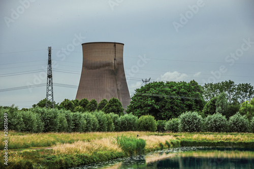 View of canal and gardens with nuclear power plant in background on cloudy day, near the village of Geertruidenberg. A small, friendly place near Aakvlaai Park and Breda. Southern Netherlands. photo