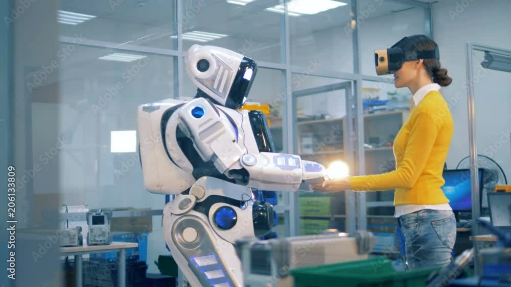 Human-like android is putting its hands on top of lady's palms Human-like android is putting its hands on top of lady's palms
