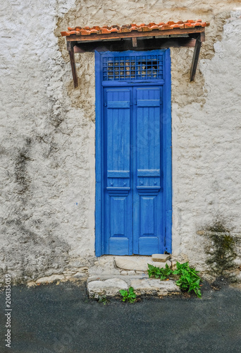 Old blue wooden doors that are shut. © jeancuomo