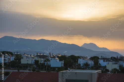 Dawn in summer over the city in the mountains with hanging clouds on the horizon at sea. Turkey, Alanya