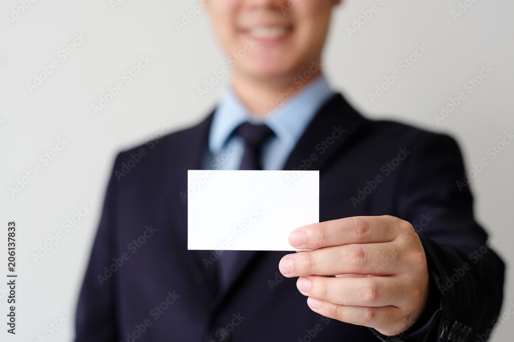 Businessman hand holding blank white business card with copy space for text, business mock up background concept Businessman hand holding blank white business card with copy space for text, business mock up background concept