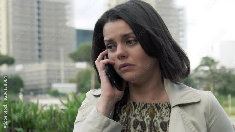 Woman on the phone in city scared of aggression slow motion Woman on the phone in city scared of aggression slow motion
