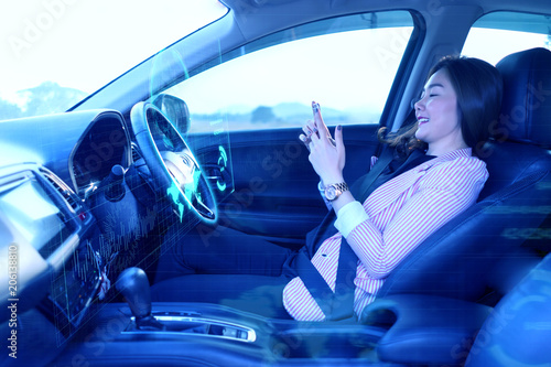 Artificial Intelligence (Ai) concept, Beautiful Asian woman using a smartphone in an autonomous car, self driving vehicle. heads up technology icon display. automotive technology driverless car © Have a nice day 