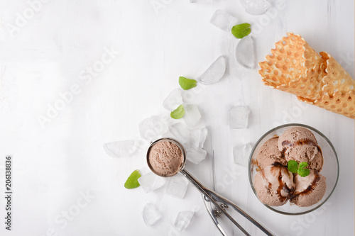 Chocolate ice cream with mint and waffle cone, and a spoon for ice cream. A top view, and with an empty space for an inscription