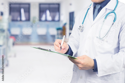Male Doctor with files and stethoscope on hospital corridor holding clipboard and writing a prescription Doctors Medical Exam Healthcare and medical concept test results  registration selective focus.