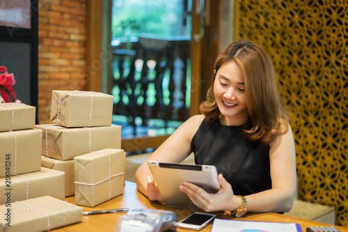 Shipping shopping online ,young start up small business owner writing address on cardboard box at workplace.small business entrepreneur SME or freelance asian woman working with box at home