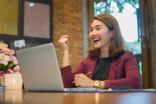 Yes! Happy excited asian woman at home with raised hands,Enjoying time, Beautiful young smiling girl working on laptop , celebrating the success business