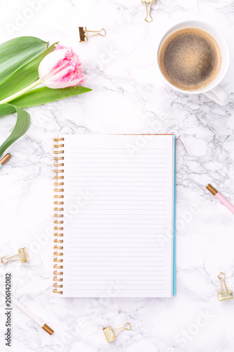 Pink tulips with festive stationary and coffee on white marble background. Feminine job, gender equality, home office and career concept. Copy space