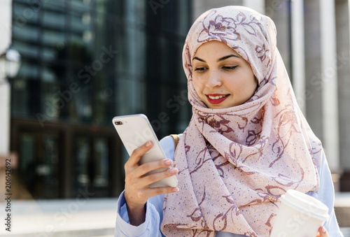 Photography Islamic woman using mobile phone and holding coffee cup