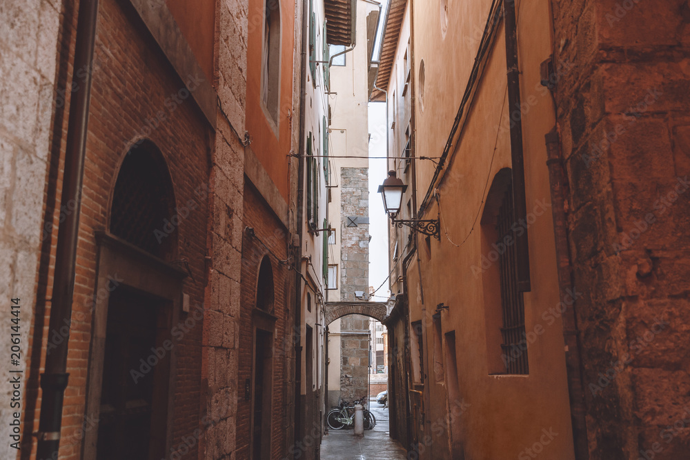 narrow alley between buildings in old city, Pisa, Italy