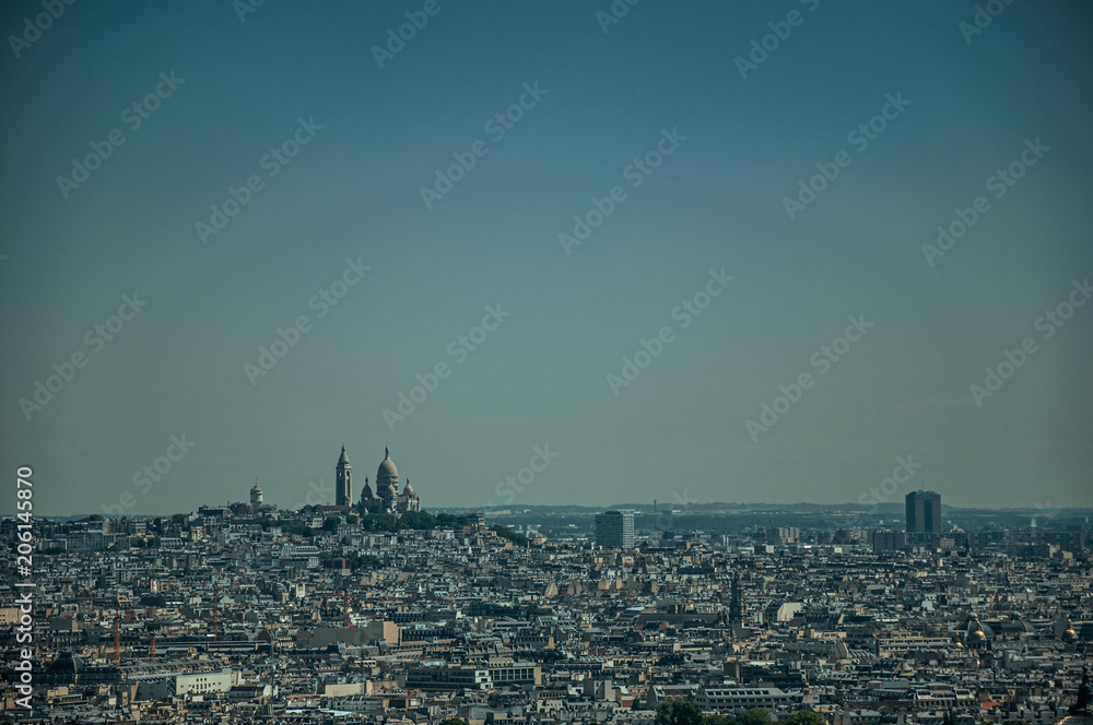 Skyline, Sacre-Coeur Basilica and buildings under blue sky, seen from the Eiffel Tower in Paris. Known as the “City of Light”, is one of the most impressive world’s cultural center. Northern France.
