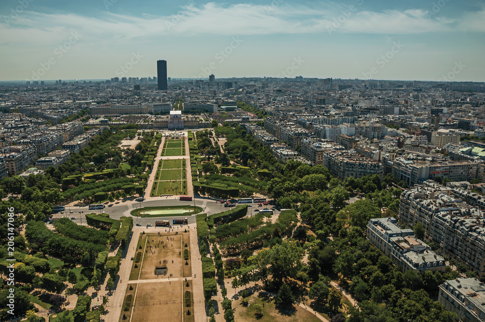 Skyline, Champ de Mars Park and buildings under blue sky, seen from the Eiffel Tower in Paris. Known as the “City of Light”, is one of the most impressive world’s cultural center. Northern France.