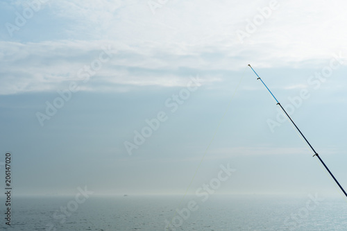 a fishing pole rod with the blue sky and the sea 