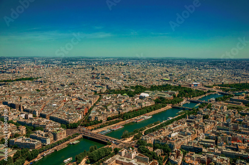 Skyline, Seine River and buildings, seen from the Eiffel Tower top in Paris. Known as the “City of Light”, is one of the most impressive world’s cultural center. Northern France. Retouched photo