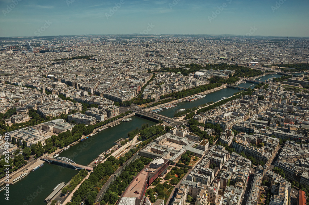 Skyline, Seine River and buildings with sunny blue sky, seen from the Eiffel Tower top in Paris. Known as the “City of Light”, is one of the most impressive world’s cultural center. Northern France.