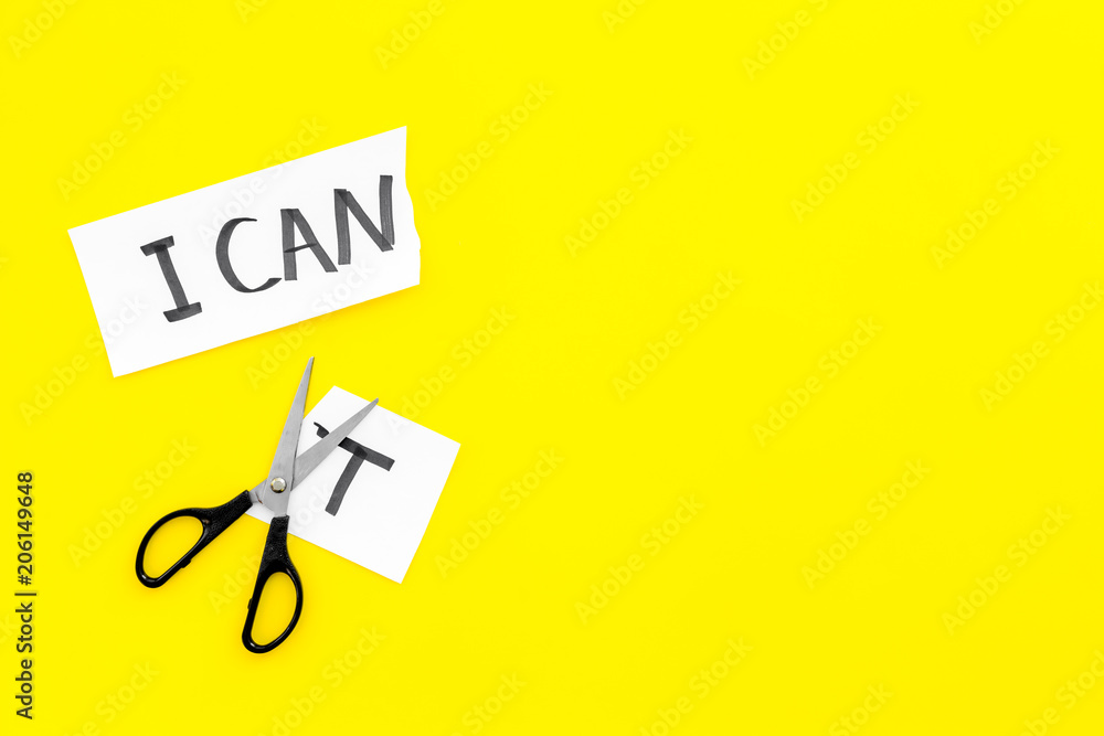 I can concept. Encourage youself. Sciccors cut off the letter t of written word I can't. Yellow background top view copy space I can concept. Encourage youself. Sciccors cut off the letter t of written word I can't. Yellow background top view copy space
