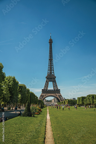 People, greenery and Eiffel Tower with sunny blue sky in Paris. Known as the “City of Light”, is one of the most awesome world’s cultural center. Northern France.