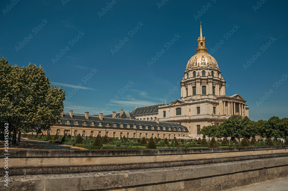 Trees in the gardens of Les Invalides Palace with the golden dome in a sunny day at Paris. Known as the “City of Light”, is one of the most impressive world’s cultural center. Northern France.