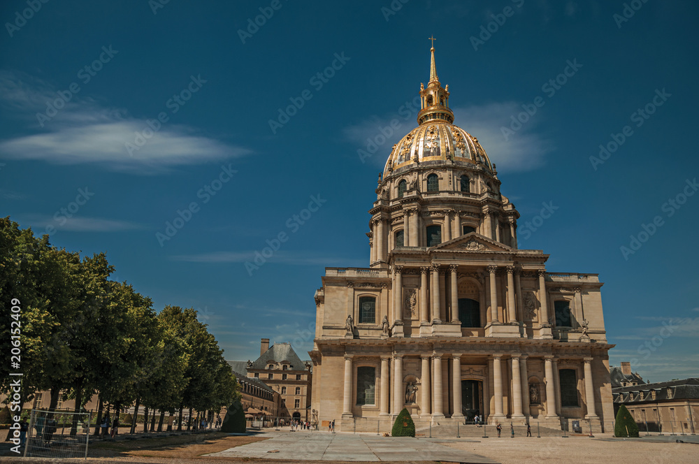 Trees and Front facade of Les Invalides Palace with the golden dome in a sunny day at Paris. Known as the “City of Light”, is one of the most impressive world’s cultural center. Northern France.