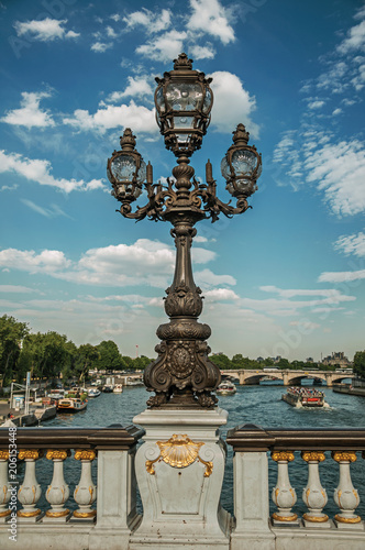 Close-up of the the lavishly decorated lamp on the Alexandre III bridge at the Seine river in Paris. Known as the “City of Light”, is one of the most awesome world’s cultural center. Northern France © Celli07