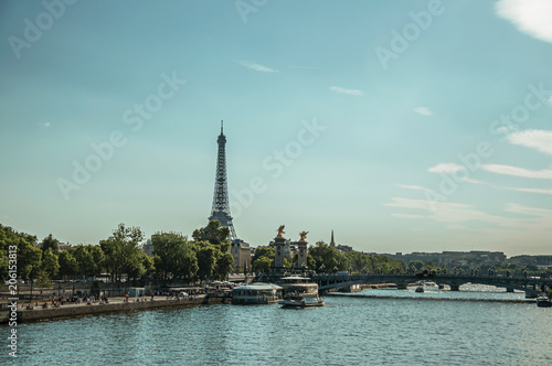 Seine River bank with boats, trees, bridge and the Eiffel Tower at sunset in Paris. Known as the “City of Light”, is one of the most impressive world’s cultural center. Northern France. © Celli07