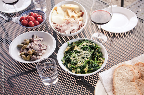 top view of mediterranean dishes: cheese, tomatoes, spinach, olives, sepia