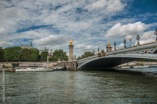 Alexandre III bridge, Grand Palais building and boats anchored at Seine River bank in Paris. Known as the “City of Light”, is one of the most impressive world’s cultural center. Northern France.