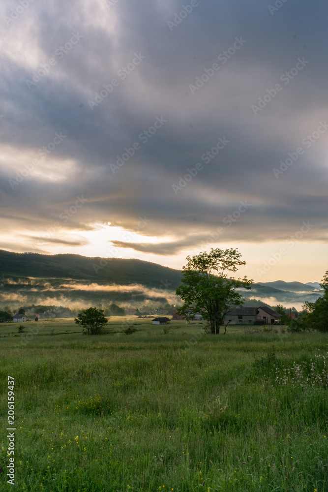 Landscape view during a misty sunrise over the  fields of Krasno polje mountain plateau near the Velebit mountain national park in Croatia. 