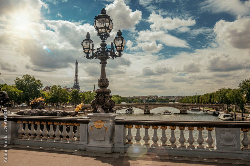 Fototapeta premium Golden statue and lighting post adorning the Alexandre III bridge over the Seine River and Eiffel Tower in Paris. Known as one of the most impressive world’s cultural center. Retouched photo.