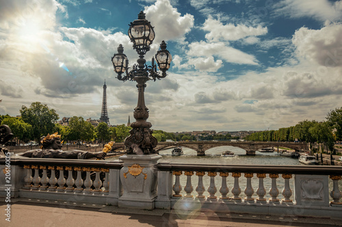 Golden statue and lighting post adorning the Alexandre III bridge over the Seine River and Eiffel Tower in Paris. Known as one of the most impressive world’s cultural center. Retouched photo.