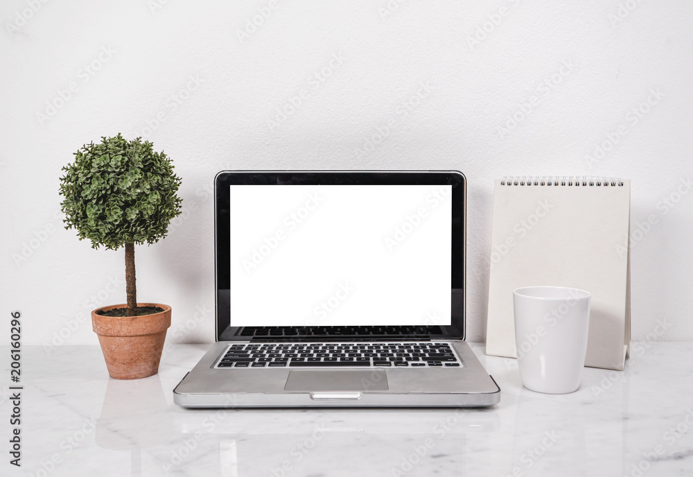 Blank screen laptop with tree pot, coffee mug and calendar, designer workplace mockup with white marble counter tabletop. Blank screen laptop with tree pot, coffee mug and calendar, designer workplace mockup with white marble counter tabletop.