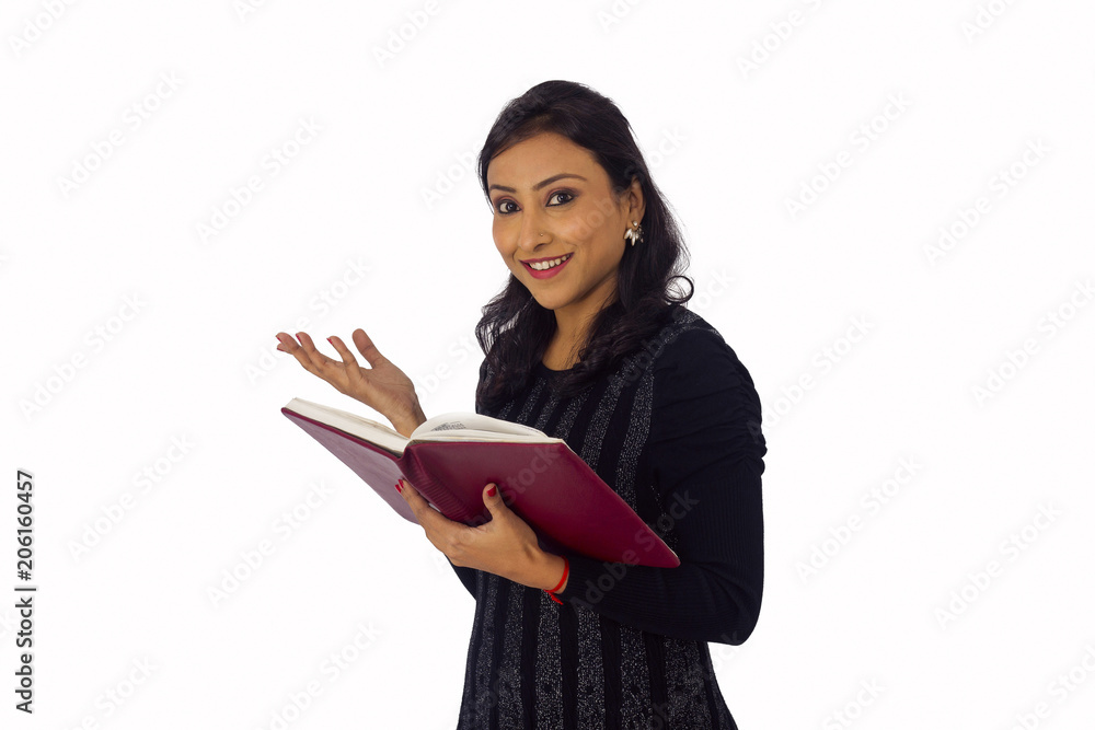 Smiling woman in black attire holding a book. Side pose Smiling woman in black attire holding a book. Side pose