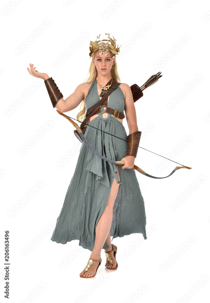 full length portrait of pretty blonde lady wearing fantasy toga gown,  and holding a bow and arrow. standing pose on white background.