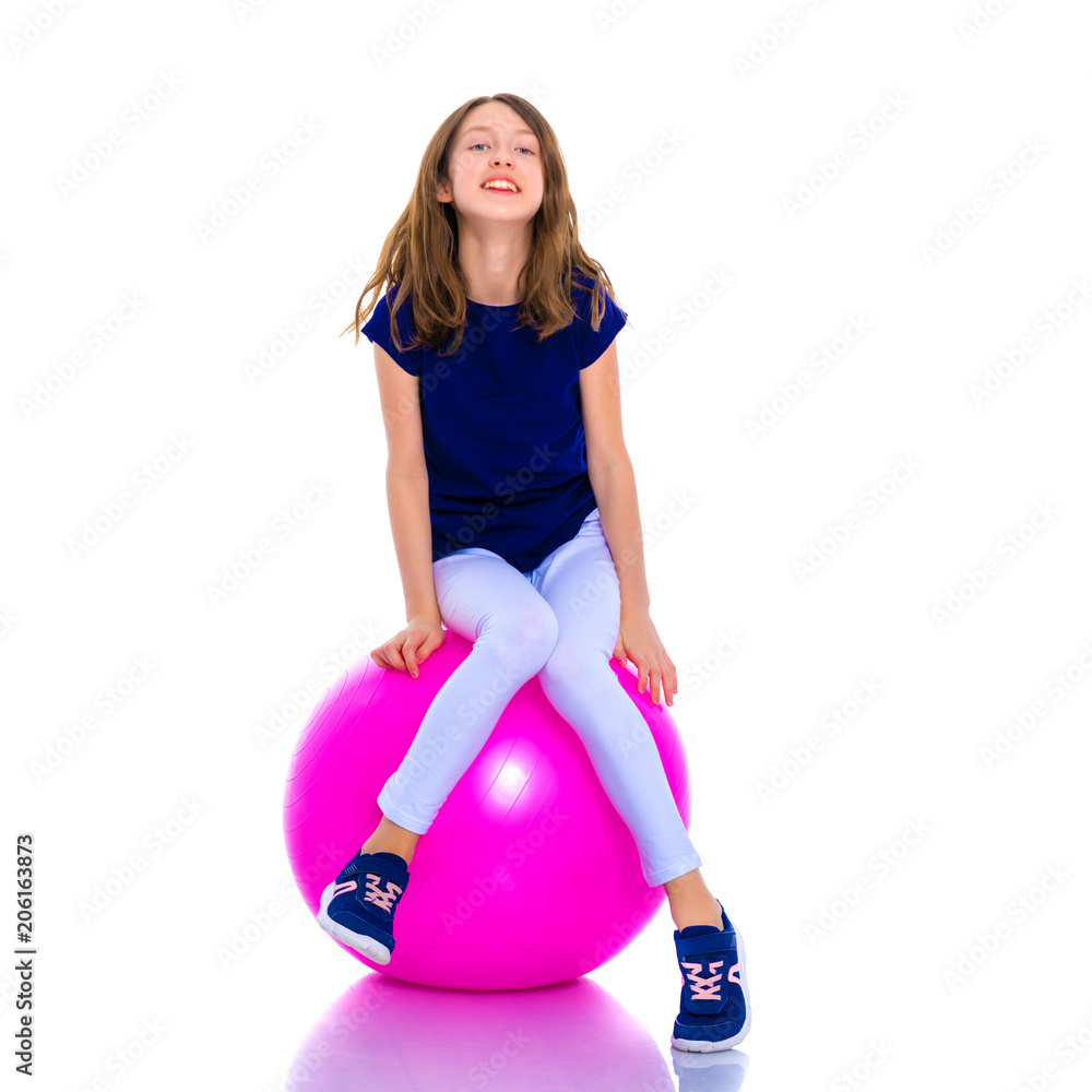 little girl doing exercises on a big ball for fitness. little girl doing exercises on a big ball for fitness.