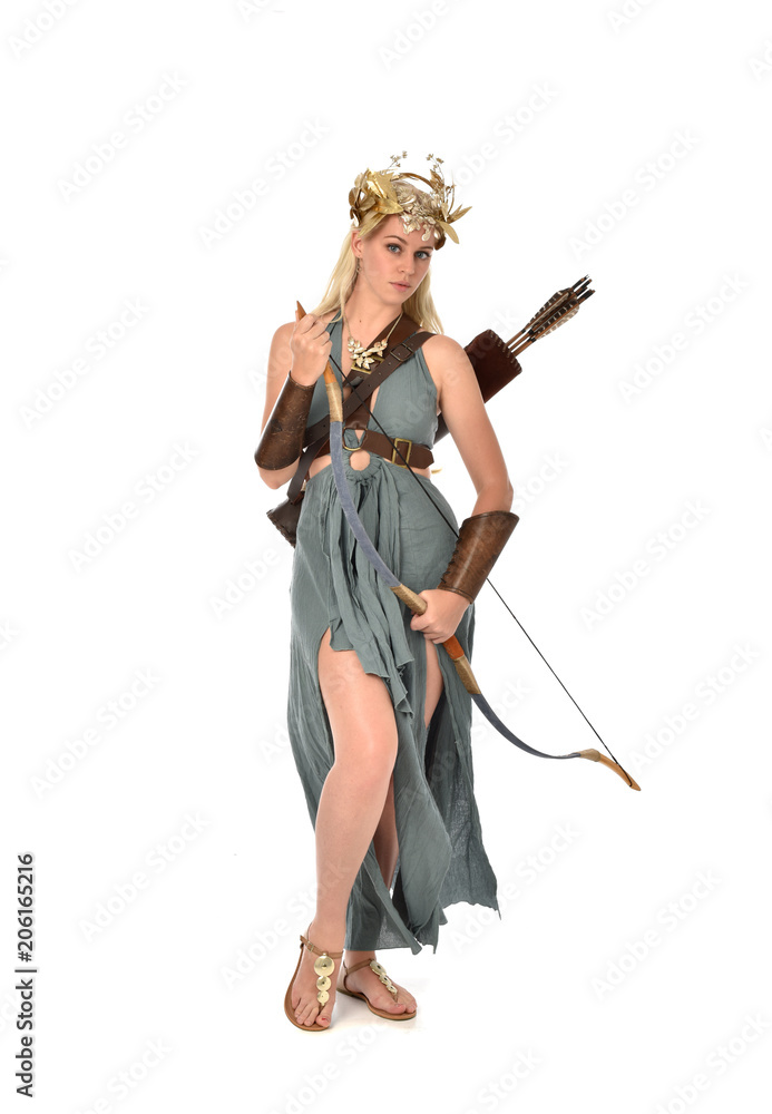 full length portrait of pretty blonde lady wearing fantasy toga gown, and holding a bow and arrow. standing pose on white background. full length portrait of pretty blonde lady wearing fantasy toga gown, and holding a bow and arrow. standing pose on white background.