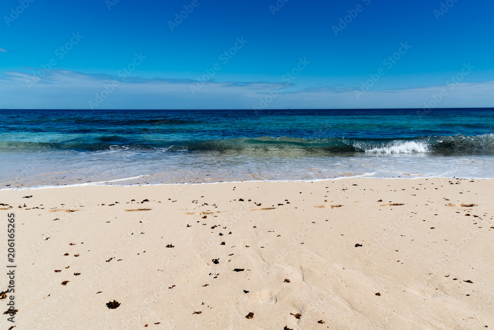 Scenic view of sandy beach and sea against blue sky