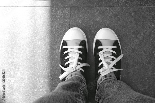 Black and white photo of a sneaker on the gray floor. Movement is life.