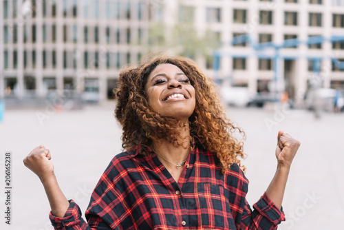 Exultant young African woman rejoicing