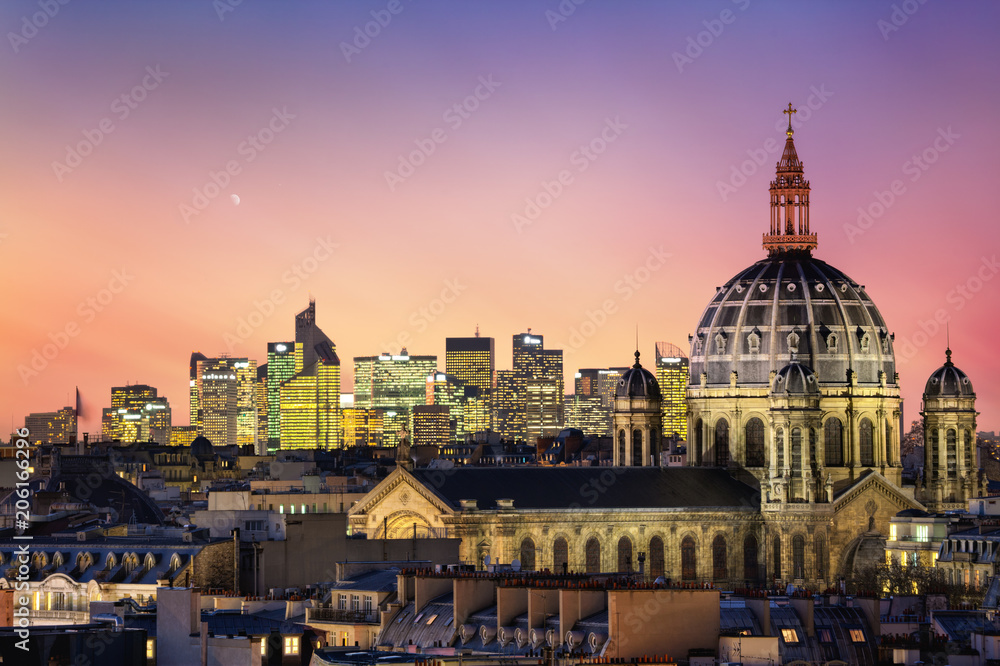 The Saint Augustin church and parisian houses with modern skyscrapers of business La Defense district in the background, France