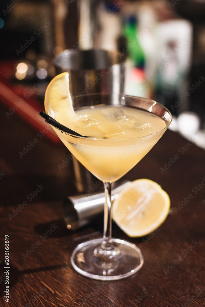 Delicious cocktail with ice cubes, lemon and straws in bar Delicious cocktail with ice cubes, lemon and straws in bar