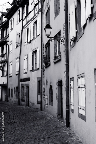 Narrow alley with cobbled street. Black and white image.