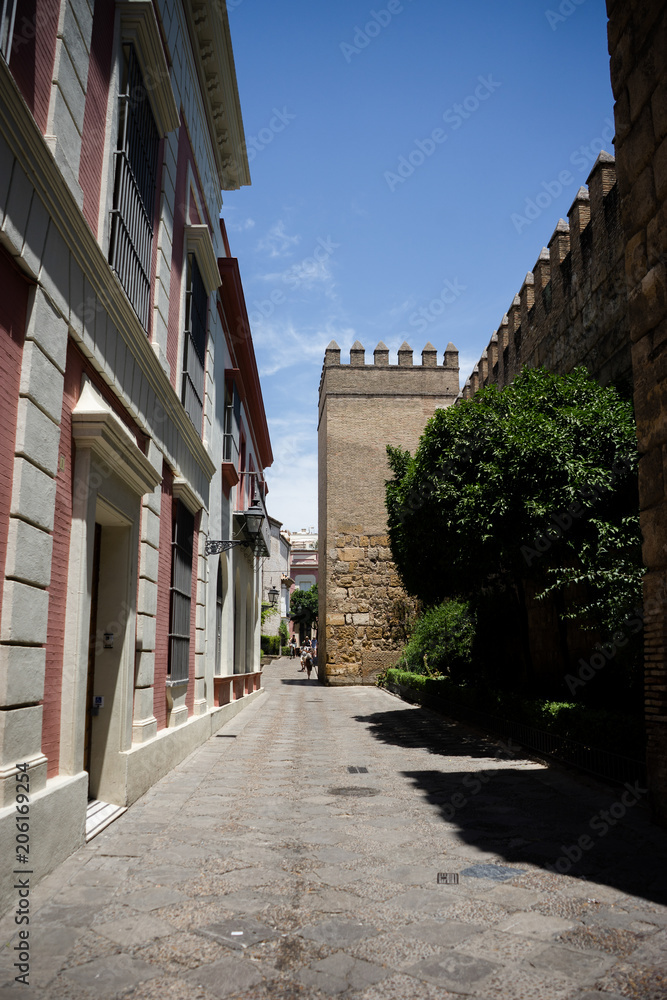 Spain, Seville, EMPTY ALLEY AMIDST BUILDINGS IN CITY next to the castle wall