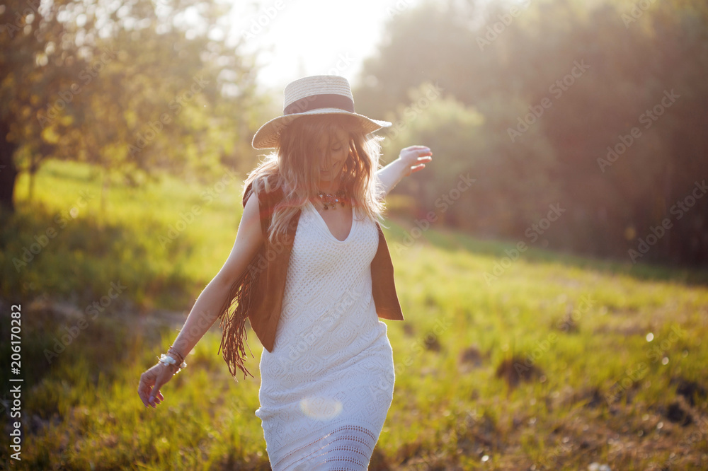 Cute charming girl in summer in the field. Young woman is happy and feels free outdoors