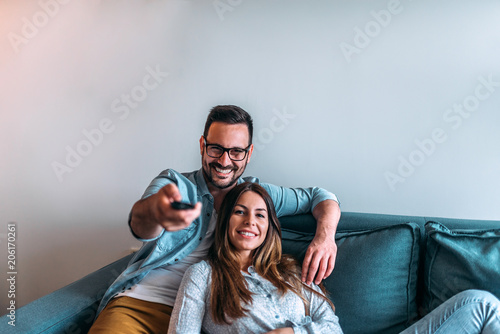 Fotografi Couple watching tv at home. Front view.