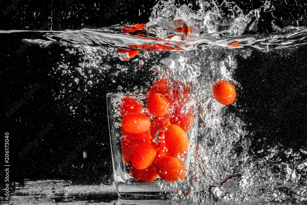 Fototapeta premium Tomatoes in glass with water splash