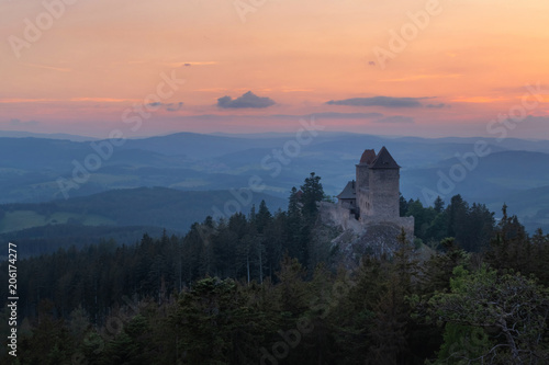 Kasperk castle after the sunset, Sumava, Czech Republic. Hills and villages in the fog, misty view on Czech landscape, evening scene.