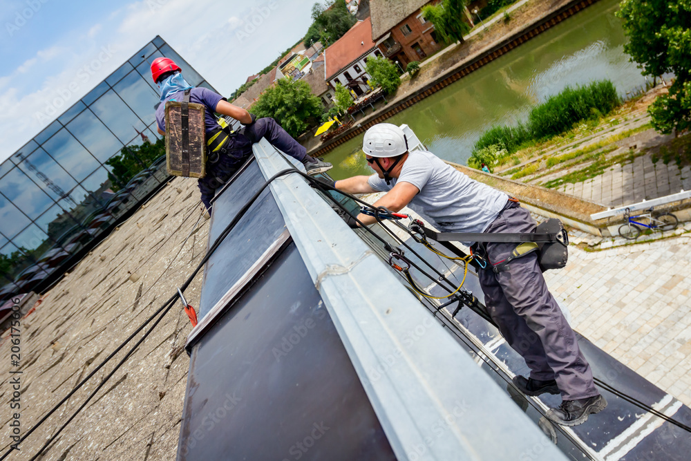 Industrial climbers are applying silicone on joints between windows Industrial climbers are applying silicone on joints between windows